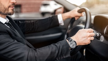 Uomo in giacca e cravatta al volante